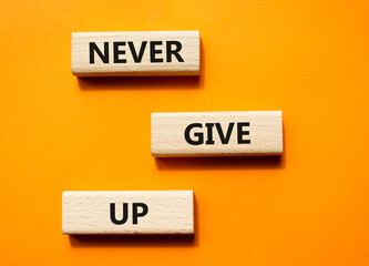 Never give up symbol. Concept words Never give up on wooden blocks. Beautiful orange green background. Business and Never give up concept. Copy space.
