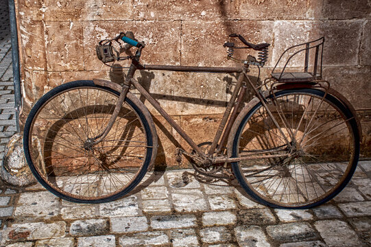 old bicycle leaned on facade.