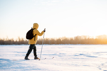 Woman in yellow jacket walking on skis in snow, warm clothes for winter sports, man actively...