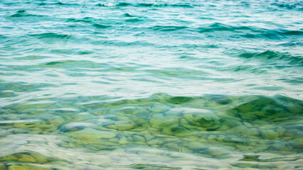 Clean transparent turquoise sea water, through which you can see pebbles on the bottom of the sea