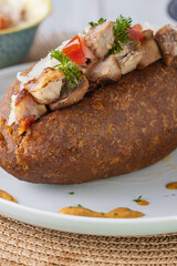 Corviche de verde relleno de carne de chancho en su interior con ensalada de tomate y cebolla y salsas, bocado típico ecuatoriano con detalle