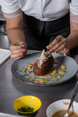 Chef Mujer adulta estilizando un corviche de cangrejo para servir al comensal