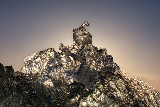 Frozen backlit glacial ice fragment on the lack Diamond beach in Iceland