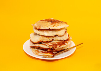 homemade pancakes on a white plate with a golden spoon