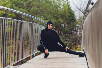 Hijab girl exercising on walkway bridge in early morning. Muslim woman wearing sports clothes doing stretching workout outdoors.