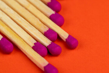 matches with a red pink substance for lighting on an orange background