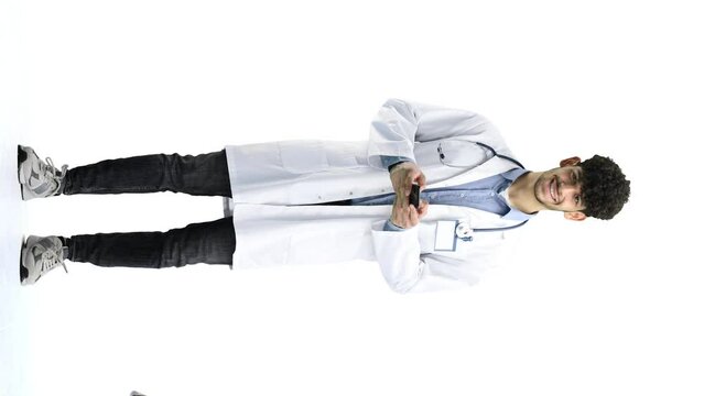 Male doctor, on a white background, full-length, with a phone