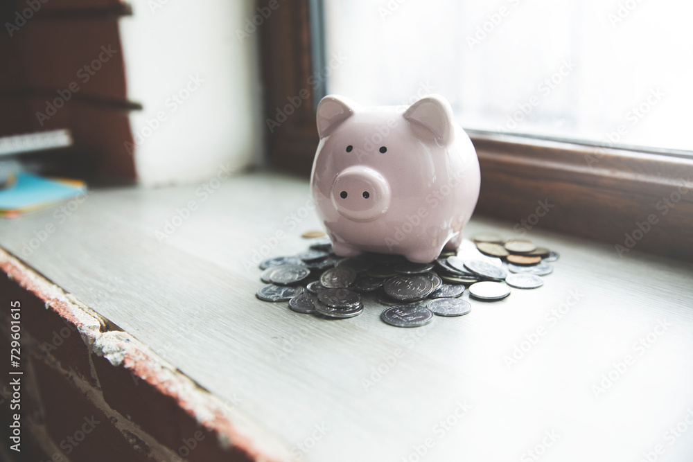 Poster a piggy bank sitting on a table in front of a window