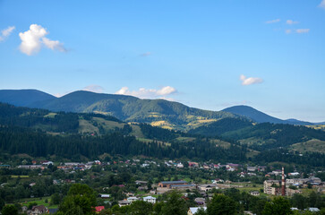 Picturesque summer landscape of the village of Verkhovyna with numerous small houses located in a valley among mountains and hills. Carpathians, Ukraine