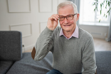 Portrait of confident stylish European middle aged senior man at home. Older mature 70s man...