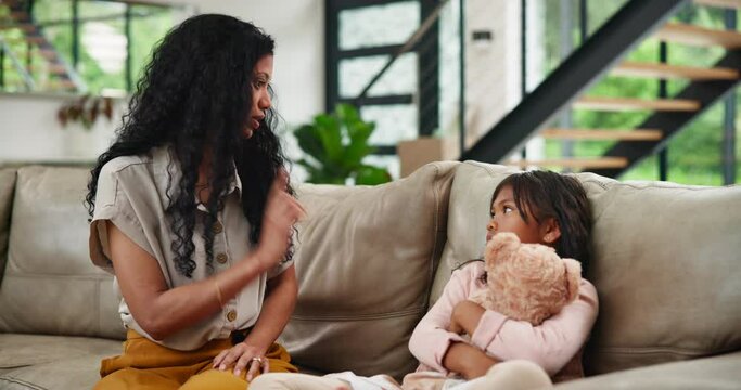 Family, teaching or discipline with mother and girl on sofa in living room of home together. Education, learning or child development with strict parent and daughter in apartment for correction