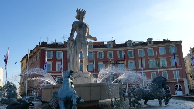 Dynamic scenes at Place Mass&eacute;na near the Fontaine du Soleil, with the iconic bronze sculpture of the Greek god Apollo, alongside the famous Ferris wheel, capturing the essence of winter 2024 in Nice