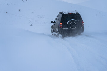 An SUV drifting in a snow field
