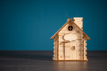Obraz na płótnie Canvas Small wooden decorative house on table, studio background
