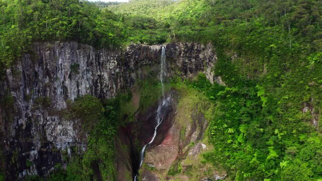 Picturesque flying over the mountain creek fall down from steep high cliff to wide green jungle valley. Cascade 500 Pieds waterfall also known as Cascade des Galets on Mauricius island in Indian ocean