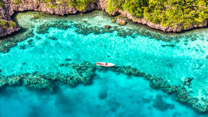 Aerial view of spear fishing boat in Fiji along coral reef.