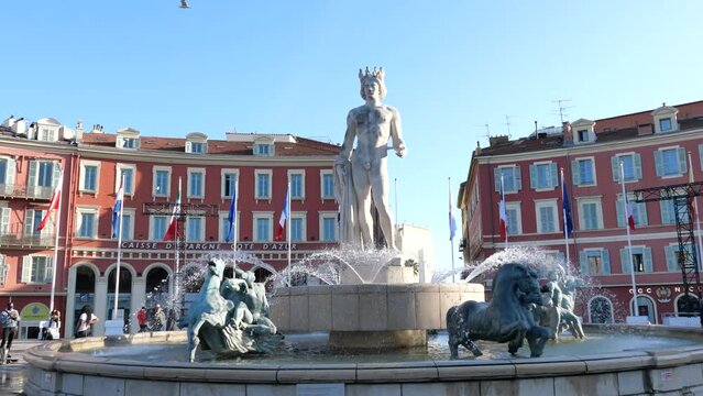 Dynamic scenes at Place Mass&eacute;na near the Fontaine du Soleil, with the iconic bronze sculpture of the Greek god Apollo, alongside the famous Ferris wheel, capturing the essence of winter 2024 in Nice