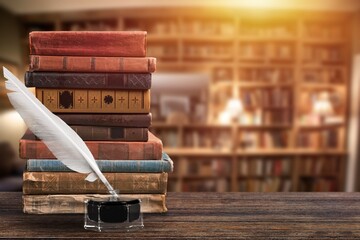 Old books, retro quill pen on wooden desk