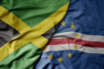 big waving national colorful flag of cape verde and national flag of jamaica .