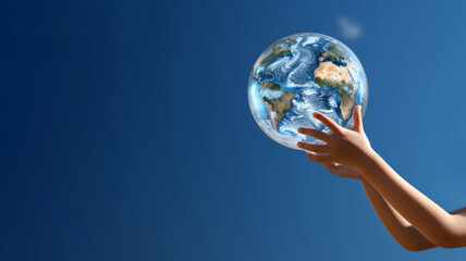 Child's hands holding glass Earth globe on blue sky background. Earth Day concept. Global environmental activism. Respect for Earth's natural environment and preserving it for future generations