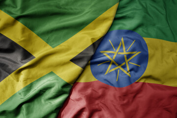 big waving national colorful flag of ethiopia and national flag of jamaica .