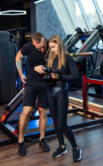 Fototapeta na wymiar Personal trainer and young woman in the gym