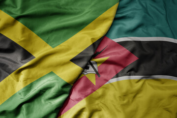 big waving national colorful flag of mozambique and national flag of jamaica .