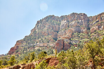 Sedona Red Rock Cliffs with Green Vegetation and Lens Flare