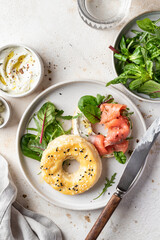 Homemade bagel sandwich with smoked salmon, cream cheese, capers and spinach for healthy breakfast...