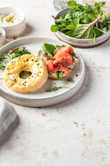Homemade bagel sandwich with smoked salmon, cream cheese, capers and spinach for healthy breakfast text space