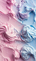 Top view of swirls of ice cream in pastel pink and blue shades with a creamy texture.