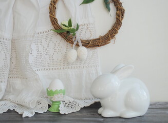white ceramic Easter bunny, bright Easter eggs and wicker wreath
