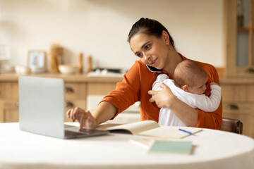 Young mother entrepreneur working from home while taking care of her infant little daughter, woman...