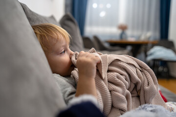 Little baby girl laying on a couch with her blanket, ready to sleep