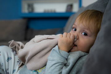 Little baby girl laying on a couch with her blanket, ready to sleep