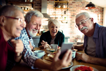 Smiling senior people having breakfast together at home