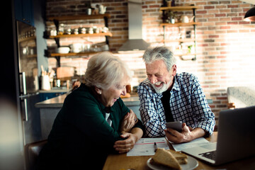 Senior couple doing home financials in the kitchen