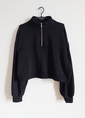 black sweatshirt on hanger isolated on white background