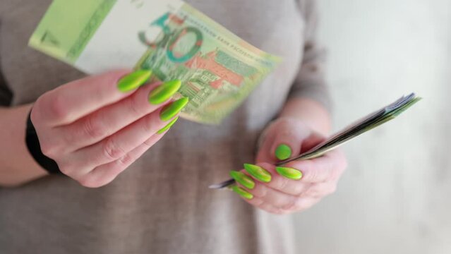 Female hands holding paper bills Belarusian rubles 