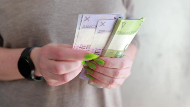 Female hands holding paper bills Belarusian rubles 