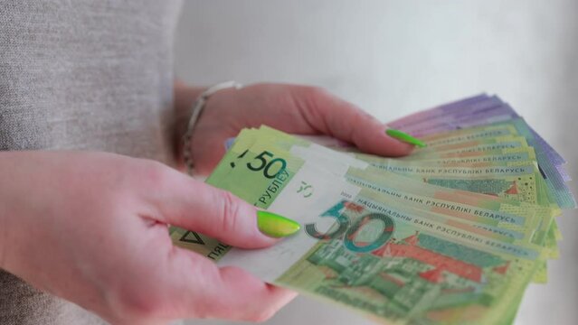 Female hands holding paper bills Belarusian rubles 