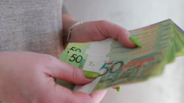 Female hands holding paper bills Belarusian rubles 