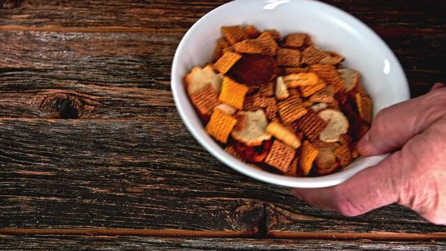 Taking away mixed crackers snacks inside  bowl and replacing with empty bowl in slow motion