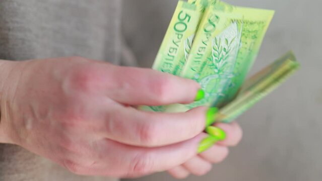 Female hands holding paper bills Belarusian rubles 