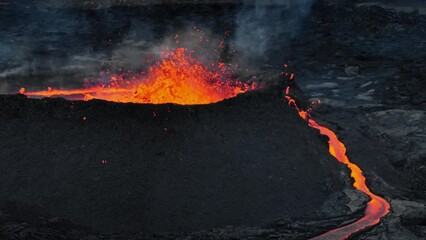 Volcanic landscape view glowing hot lava streams, molten lava stream river in slow motion, panorama aerial shot. Natural hazard and environmental concepts.
