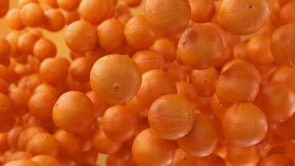 Juicy oranges floating against orange background