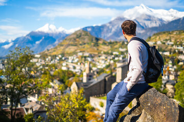 Man admiring the view of historical Sion town,spectacular set in the swiss Alps mountains valley,...