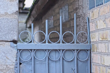 part of a gray metal fence wall with rebar rods on the street