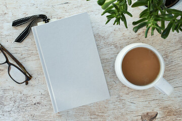 Blank 5.5x8.5 book cover for mock up with coffee, plant and reading glasses.