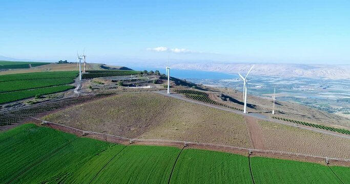 Aerial footage of a wind turbine in the mountains above the Sea of Galilee.